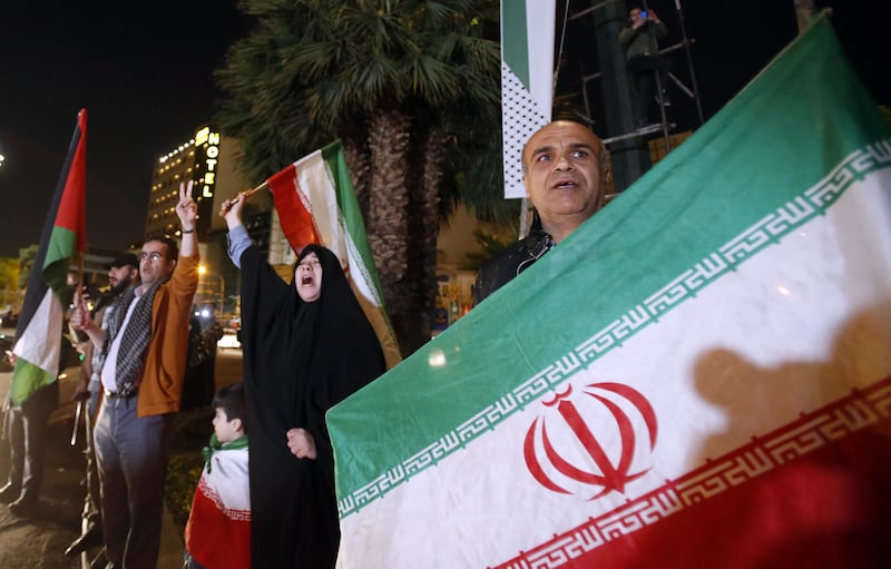People hold Iranian and Palestinian flags at Palestine Square in Tehran. EPA
