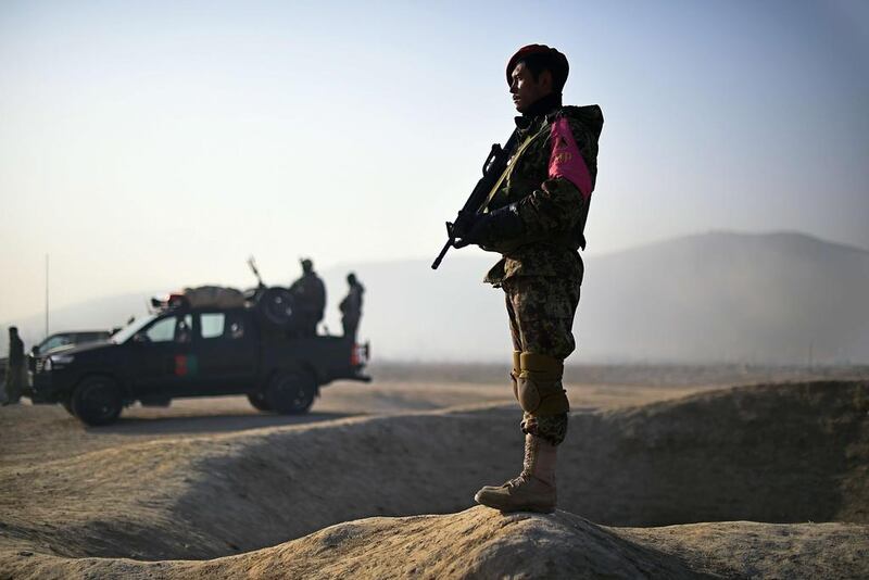 Afghan security forces keep watch at the site of a suicide attack on the outskirts of Kabul on December 18, 2014. Shah Marai/AFP Photo

