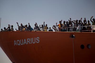 In this photo taken on Sunday, Aug. 21, 2016, migrants wave from SOS Mediterranee Aquarius rescue ship, after being rescued by members of the Spanish NGO Proactiva Open Arms during an operation at the Mediterranean sea, about 12 miles north of Sabratha, Libya. Italy's new "Italians first" government claimed victory Monday June 11, 2018, when the Spanish prime minister offered safe harbor to a private rescue ship after Italy and Malta refused to allow it permission to disembark its 629 migrant passengers in their ports. (AP Photo/Emilio Morenatti)