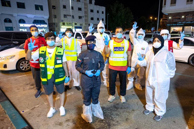 Abu Dhabi, United Arab Emirates, June 22, 2020.   
STORY BRIEF: Police patrols knocking on doors offering free Covid-19 tests to residents in buildings in AD downtown, Al Bakra Street area.
--  Captain Ayesha Al Mersad (center) and her team at the Al Bkra Street neighborhood.
Victor Besa  / The National
Section:  NA
Reporter:  Haneen Dajani