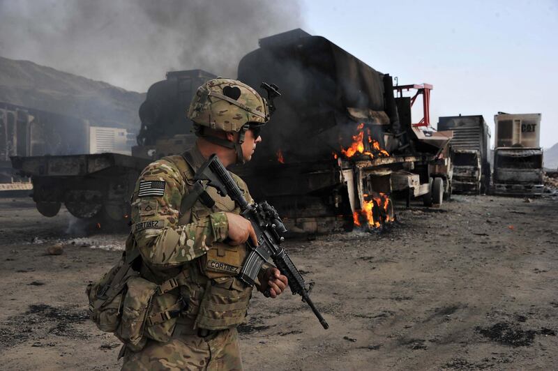 (FILES) In this file photo taken on June 19, 2014, a US soldier investigates the scene of a suicide attack at the Afghan-Pakistan border crossing in Torkham, Nangarhar province. The US and the Taliban are set to sign a historic agreement that would pave the way to ending America's longest war, the bitter foes announced on February 21, hours after Kabul said a week-long partial truce across Afghanistan would kick off this weekend.
 / AFP / Noorullah Shirzada
