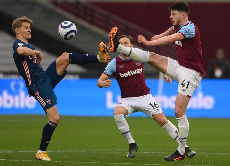 Arsenal's midfielder Martin Odegaard and West Ham United's midfielder Declan Rice fight for the ball. AFP