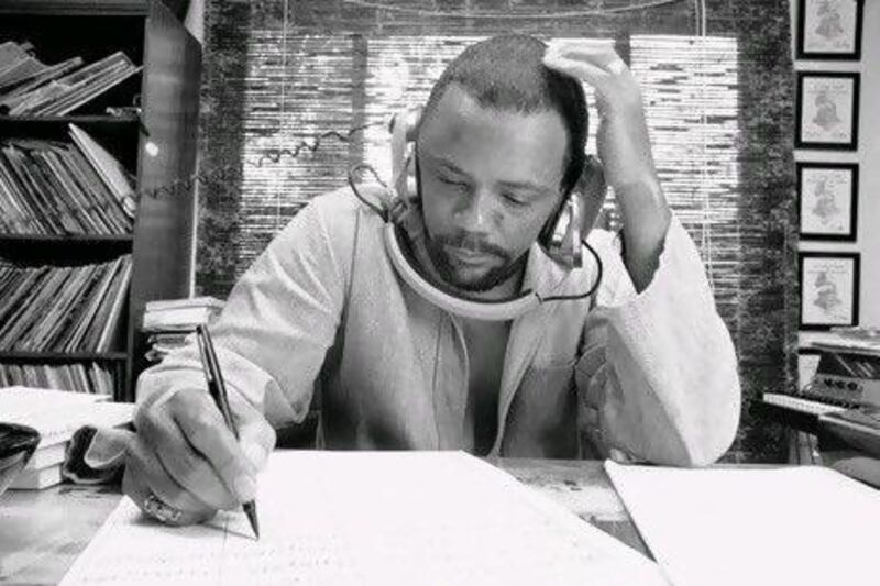 Composer Quincy Jones at his home studio in October 1974 writing music, listening to a recording on his headphones.