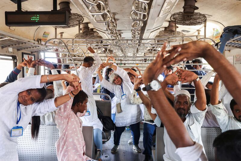 People perform yoga in a local train, during International Yoga Day in Mumbai, India. Reuters