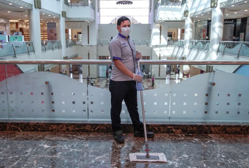 Bam Babhdur, from Nepal, is a cleaner at the Khalidiyah Mall. He says: "I have protective equipment to keep safe.  I am not scared; I am doing my duty." Victor Besa / The National