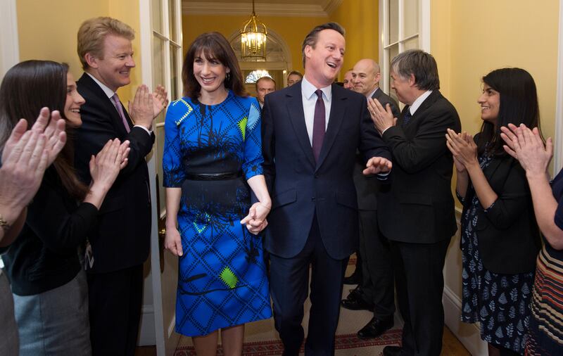 Mr Cameron and his wife Samantha are applauded by staff upon entering 10 Downing Street as he begins his second term as Prime Minister in May 2015