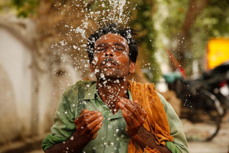 An Indian worker splashes water on his face to cool himself on a hot summer afternoon in Prayagraj, Uttar Pradesh. AP Photo