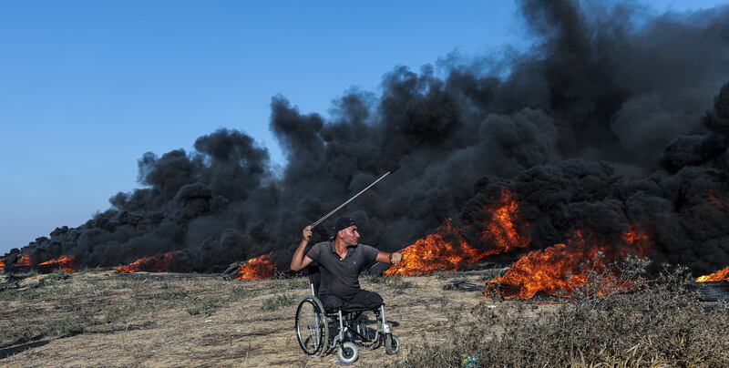 A Palestinian protester throws stones at Israeli troops during clashes on Friday. EPA