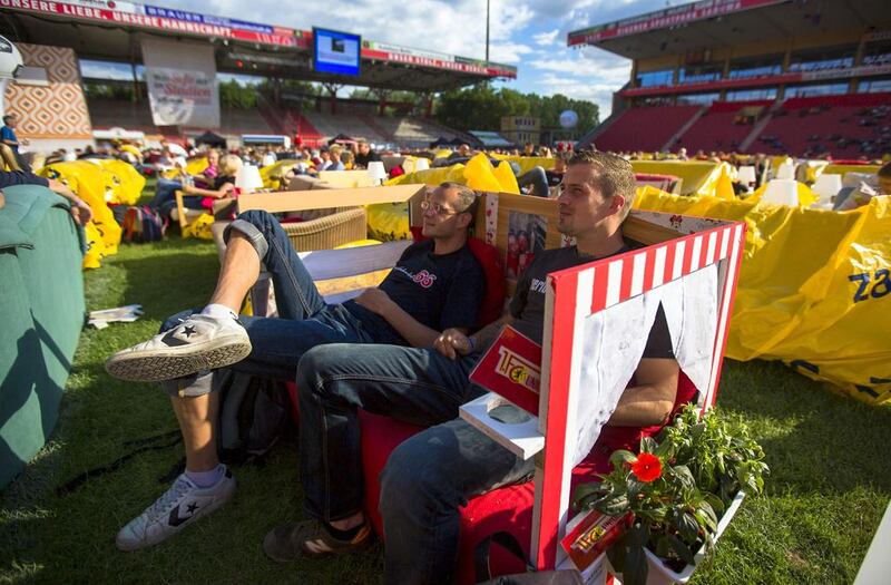 People sit on sofas as they watch a 2014 World Cup match at Berlin Union's Alte Forsterei stadium, where public viewings of the World Cup are being held in a vast 'World Cup living room'. Thomas Peter / Reuters