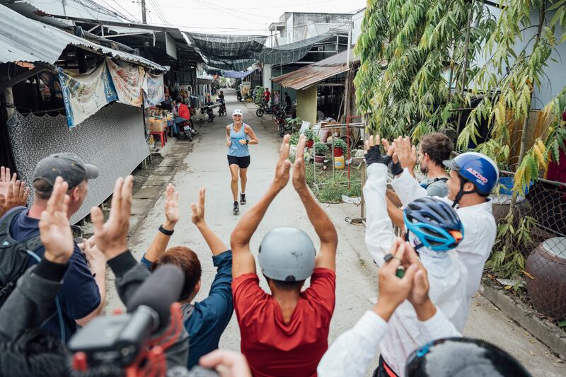 Guli runs towards her team at the end of marathon 150 in Vietnam