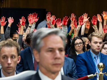 Protesters calling for a ceasefire in Gaza raise their arms as US Secretary of State Antony Blinken testifies in Washington last October. EPA