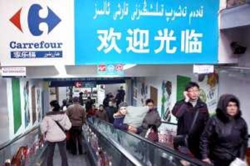 Shoppers carry goods in a Carrefour store in Urumqi, China, on Friday, Dec. 28, 2007. Carrefour SA, Europe's largest retailer, may report the first quarterly sales decline in six years this week as French and Spanish consumers retrenched and growth slowed in China. Photographer: Jean Chung/Bloomberg News