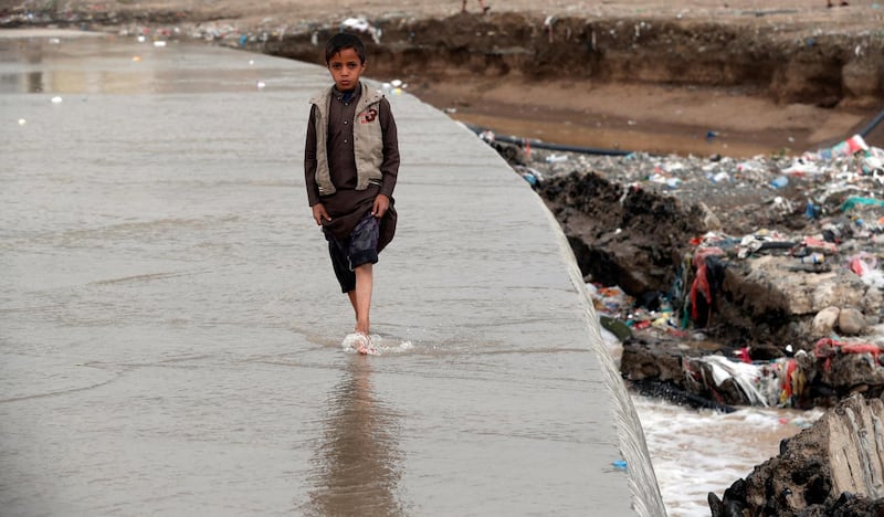 A Yemeni child walks through a flooded stream of rainwater following heavy rains in Sana'a, Yemen.  EPA