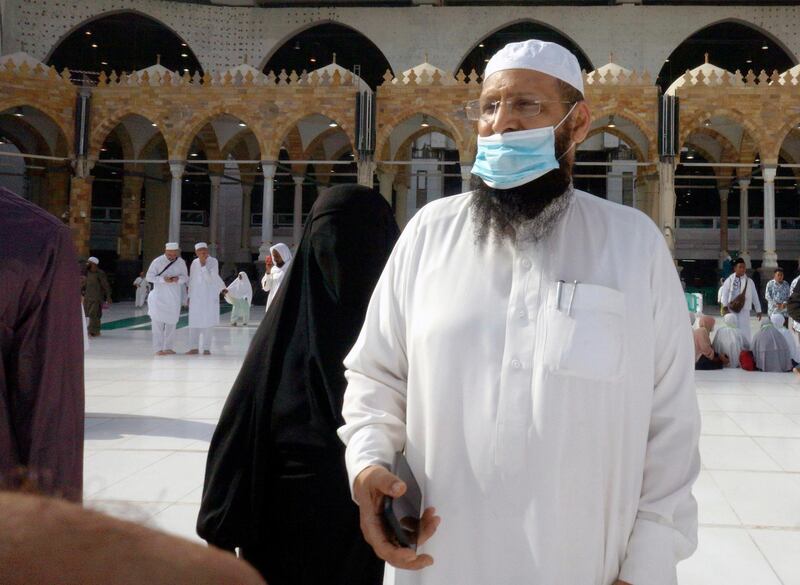 A pilgrim wears a mask as he visits the Grand Mosque in Makkah. AP Photo
