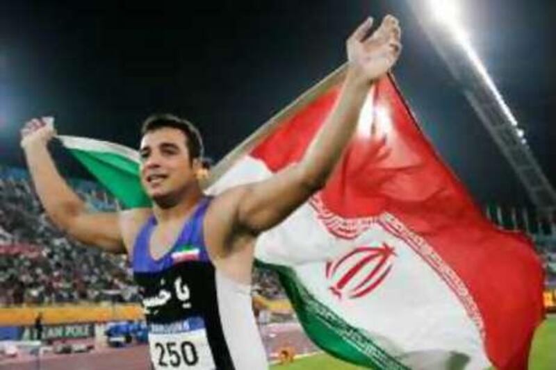 Iran's Ehsan Hadadi carries his national flag as he celebrates his win in the men's discus throw finals at the 15th Asian Games in Doha December 10, 2006.     REUTERS/Jason Reed   (QATAR)
Picture Supplied by Action Images *** Local Caption *** 2006-12-10T151645Z_01_DOH239_RTRIDSP_3_GAMES-ASIAN-ATHLETICS.jpg