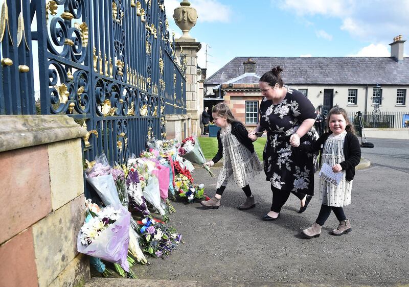 Naomi Armstrong and her daughters Lily and Essie leave a bunch of flowers at the gates of Hillsborough Castle, Northern Ireland, in tribute to Prince Philip. Getty Images