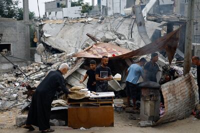 Palestinians prepare food next to destroyed buildings, following Israeli strikes in Khan Younis, Gaza, on Monday. Reuters