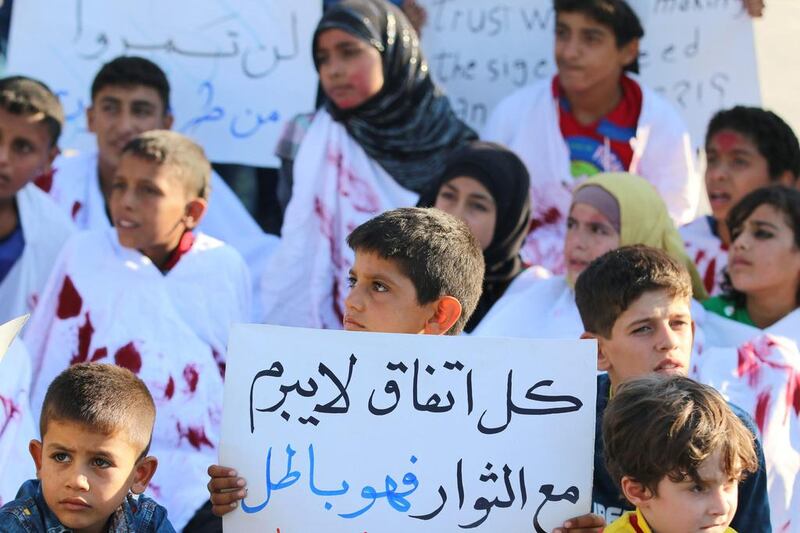A boy carries a placard during a demonstration against forces loyal to Syria's President Bashar al-Assad and calling for aid to reach Aleppo near Castello road in Aleppo, Syria, September 14, 2016. The placard reads in Arabic, "Every agreement which is not done with the rebels is void."  Abdalrhman Ismail / Reuters 