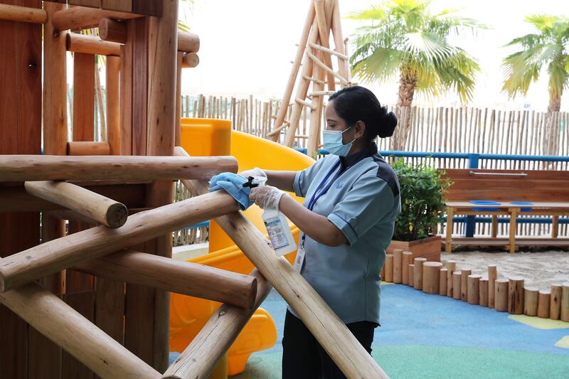 Staff cleaning the play area at Brighton College Dubai. Pawan Singh/The National