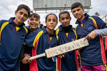 Players from Alsama Shatila Hub 1 pose with bat signed by players from England and Pakistani cricket team in Beirut, Lebanon on 27 February 2022. (Matt Kynaston)