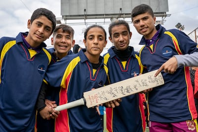 Players from Alsama Shatila Hub 1 pose with a bat signed by players from the England and Pakistani cricket teams. Matt Kynaston
