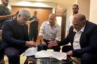 From left, seated, Yesh Atid, leader of Yair Lapid, Yamina party leader Naftali Bennett and Ra'am party leader Mansour Abbas will be part of a disparate coalition. Ra'am via Reuters