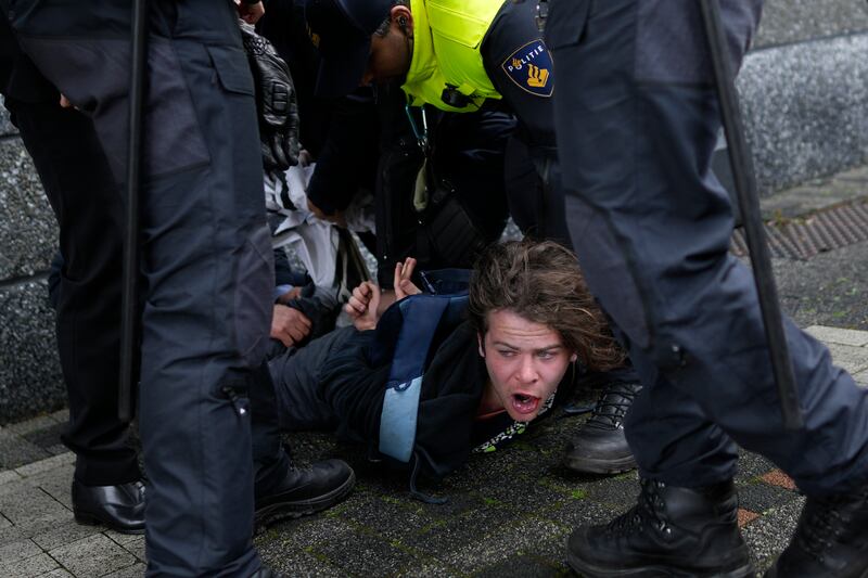 A protester is pinned to the ground by guards after he ran towards French President Emmanuel Macron outside the University of Amsterdam in the Netherlands on Wednesday. AP