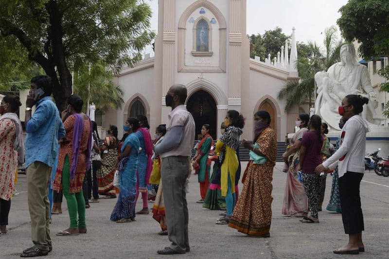 People wait to receive food during a lockdown imposed against the spread of Covid-19, at Saint Marys Basilica in Secunderabad, the twin city of Hyderabad. AFP