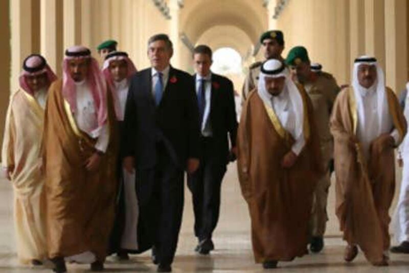 British Prime Minister Gordon Brown (C) walks with Saudi officials on his arrival at King Saud university in Riyadh November 2, 2008. The IMF needs hundreds of billions of dollars to protect struggling economies from the global financial crisis, Brown said on Sunday, as he led a business and ministerial delegation to the Gulf States.   REUTERS/Stringer   (SAUDI ARABIA) *** Local Caption ***  AMM116_BRITAIN-GULF_1102_11.JPG