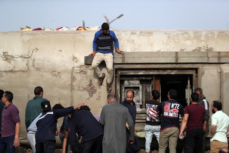 People inspect the damage at the site where train carriages derailed in Qalioubia province, north of Cairo, Egypt. Reuters