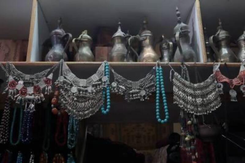 Traditional coffee pots, known as dallahs, and jewellery are some of the many antiques for sale at the souq’s stores. Jeffrey E Biteng / The National