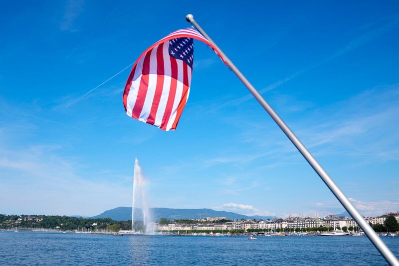 The United States flag waves  near the fountain Jet d'eau in Lake Geneva. AP Photo