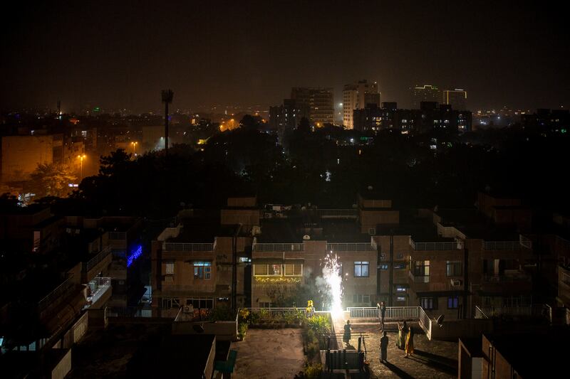 People set off firecrackers on the terrace of a building. AP Photo