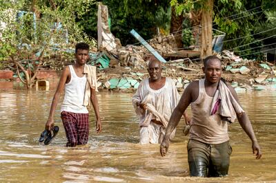 Men walk through a flooded area in Al Sagai area, north of Omdurman, in the Sudanese capital. AFP