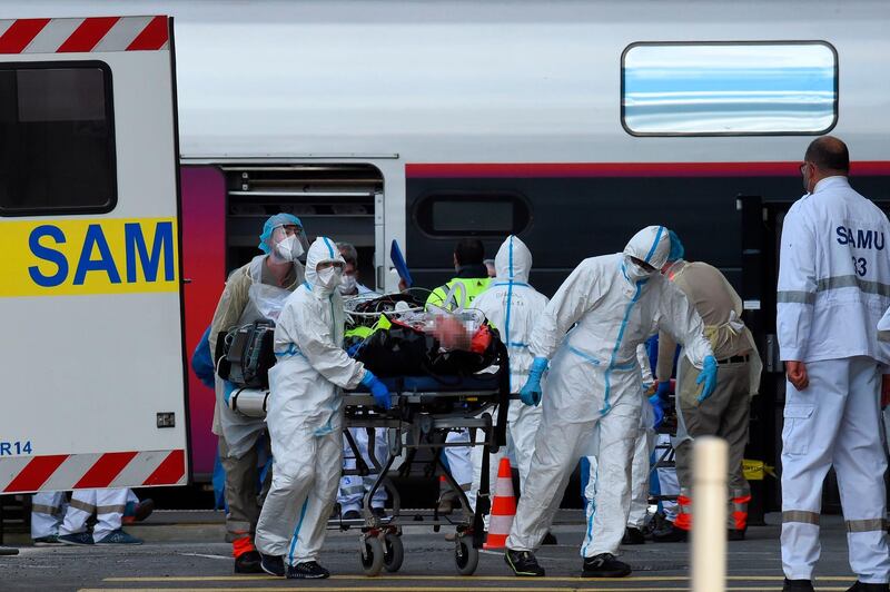 Medical staff members gather before carrying patients infected with the novel coronavirus as they arrive at the Saint-Jean train station in Bordeaux, southwestern France. AFP