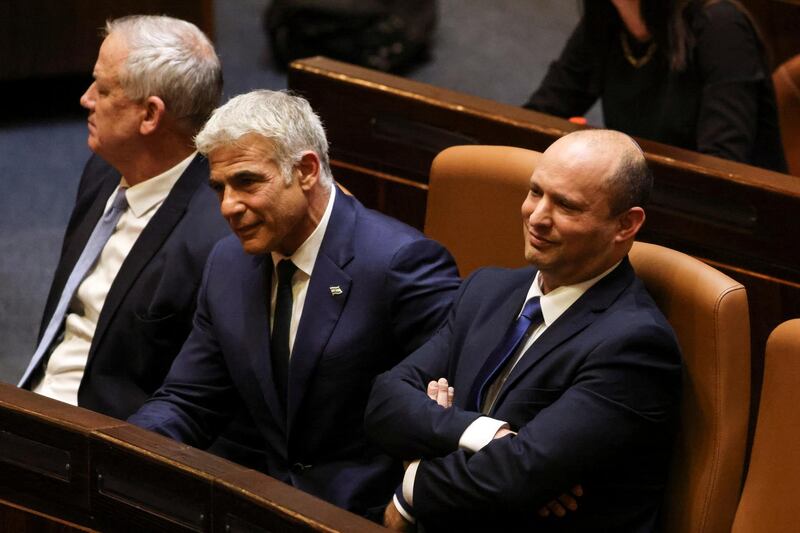 New Israeli Prime Minister Naftali Bennett, Foreign Minister Yair Lapid and Defence Minister Benny Gantz sit in parliament, in Jerusalem, on June 13, 2021. Mr Bennett was sworn in after winning a confidence vote with a margin of 60 votes to 59. Reuters