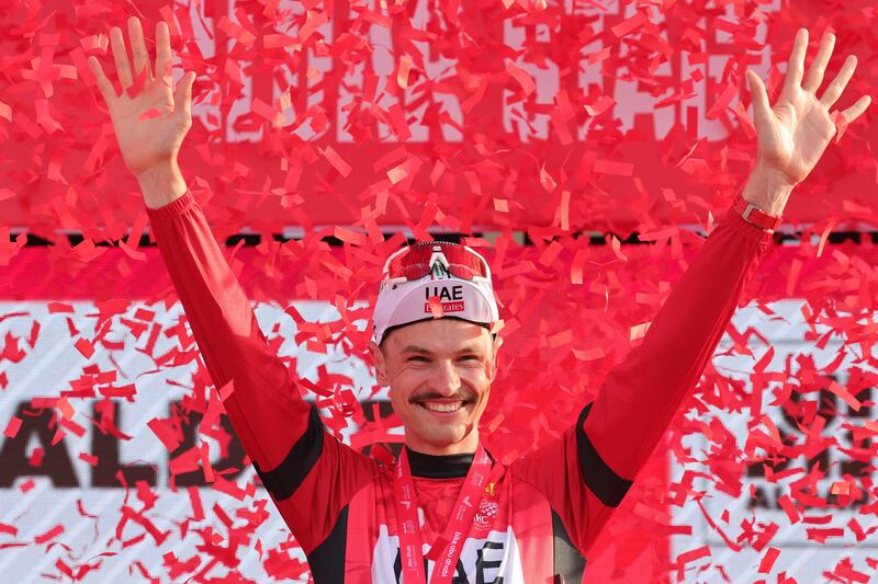 UAE Team Emirates' Australian cyclist Jay Vine celebrates in the red jersey after he maintained his lead in the race's general classification after Stage 6. AFP