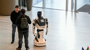 Guests entertained by a robot at the Mohamed bin Zayed University of Artificial Intelligence (MBZUAI) inaugural commencement ceremony in Abu Dhabi. Khushnum Bhandari / The National 