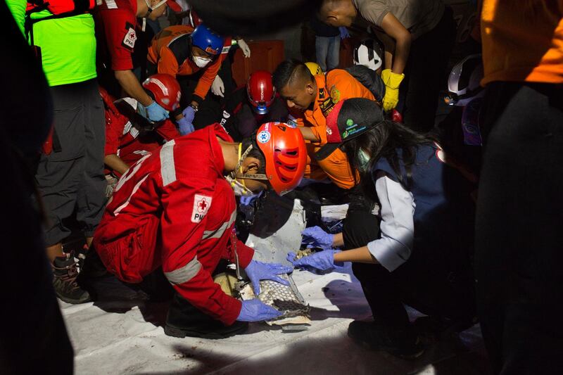 Search and rescue workers load the body of a victim. Ed Wray