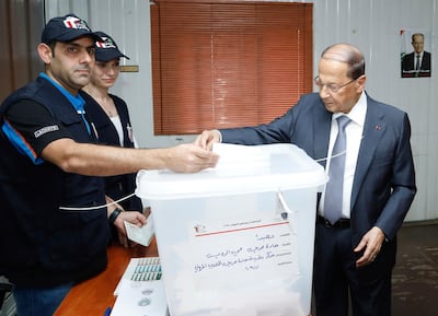 In this photo released by Lebanon's official government photographer Dalati Nohra, Lebanese President Michel Aoun, right, casts his vote for Lebanon's parliamentary elections, at a polling station, in the southern suburb of Beirut, Lebanon, Sunday, May 6, 2018. Lebanon's polling stations have opened for the first parliamentary elections in nine years. (Dalati Nohra via AP)