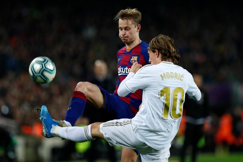 Barcelona's Frenkie de Jong, left, passes the ball as Real Madrid's Luka Modric defends. AP