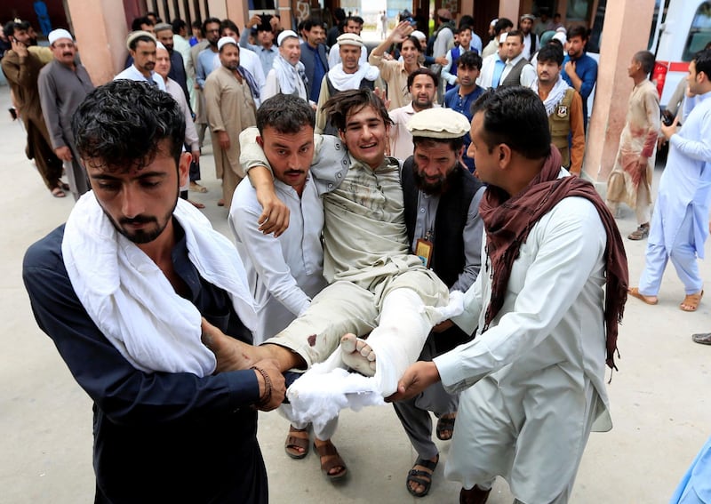 Afghan men carry an injured man to a hospital after a suicide attack, in Jalalabad, Afghanistan October 2, 2018. REUTERS/Parwiz