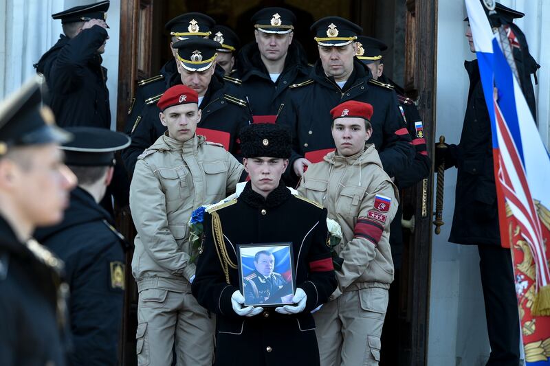 A serviceman carries the photo of Captain Andrei Paliy, a deputy commander of Russia's Black Sea Fleet, during a farewell ceremony in Sevastopol, Crimea. AP