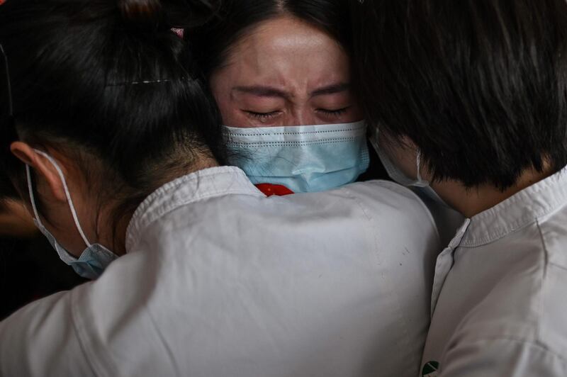 Medical staff from Jilin Province hug nurses from Wuhan after working together during the coronavirus outbreak, during a ceremony before leaving as Tianhe Airport is reopened.  AFP