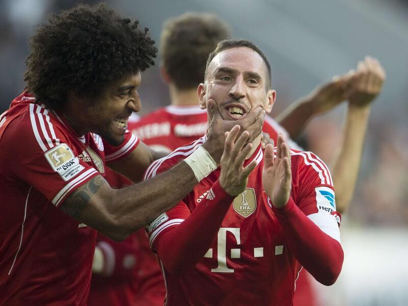 Bayern Munich’s French midfielder Franck Ribery, right, celebrates scoring his side’s fourth goal with team mate Dante during the German first division Bundesliga football match VfL Wolfsburg vs Bayern Munich on March 8, 2014 in Wolfsburg, central Germany. Odd Anderson / AFP