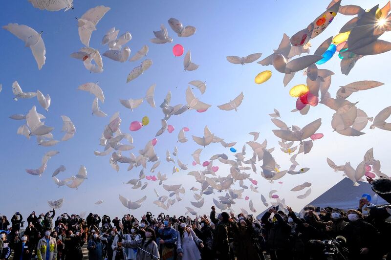 People release dove-shaped balloons into the sky to mourn earthquake and tsunami victims in Natori, Miyagi prefecture, during the 10th anniversary of the 9.0-magnitude earthquake, which triggered a tsunami and nuclear disaster, killing more than18,000 people.  AFP