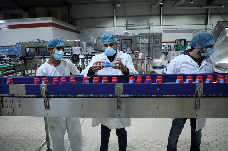 Iraqi workers inspect the products at a dairy factory in Basra, Iraq. Reuters