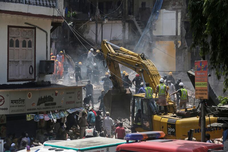 Rescue workers clear debris. Rafiq Maqbool / AP Photo