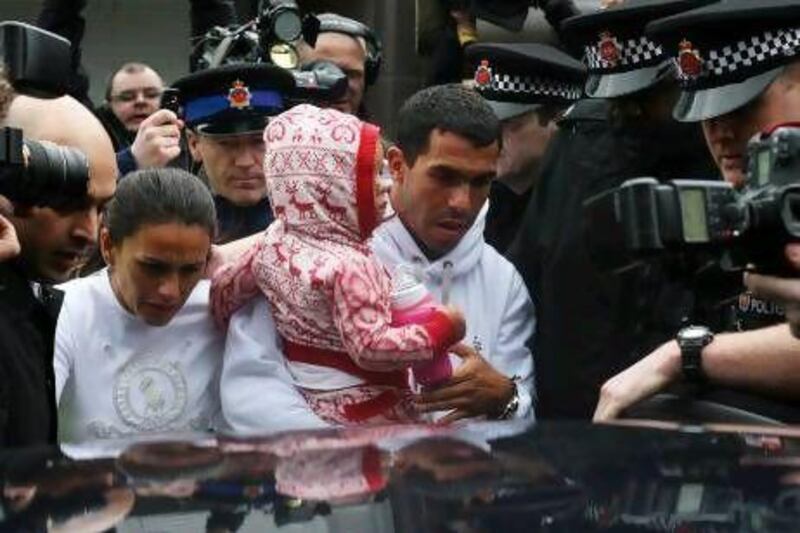 Carlos Tevez, centre, arrives with his family, a British Police security escort and media following at Manchester Airport.