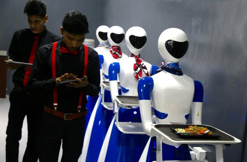 Stewards still work at the restaurant, and check the incoming food orders on a tablet. At the first of its kind Restaurant in Bangalore, six robots are deployed as waiters. Photo: EPA/JAGADEESH